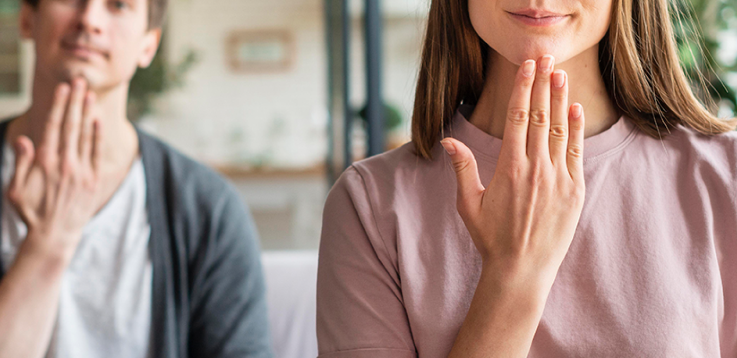 Front view of couple communicating with sign language.